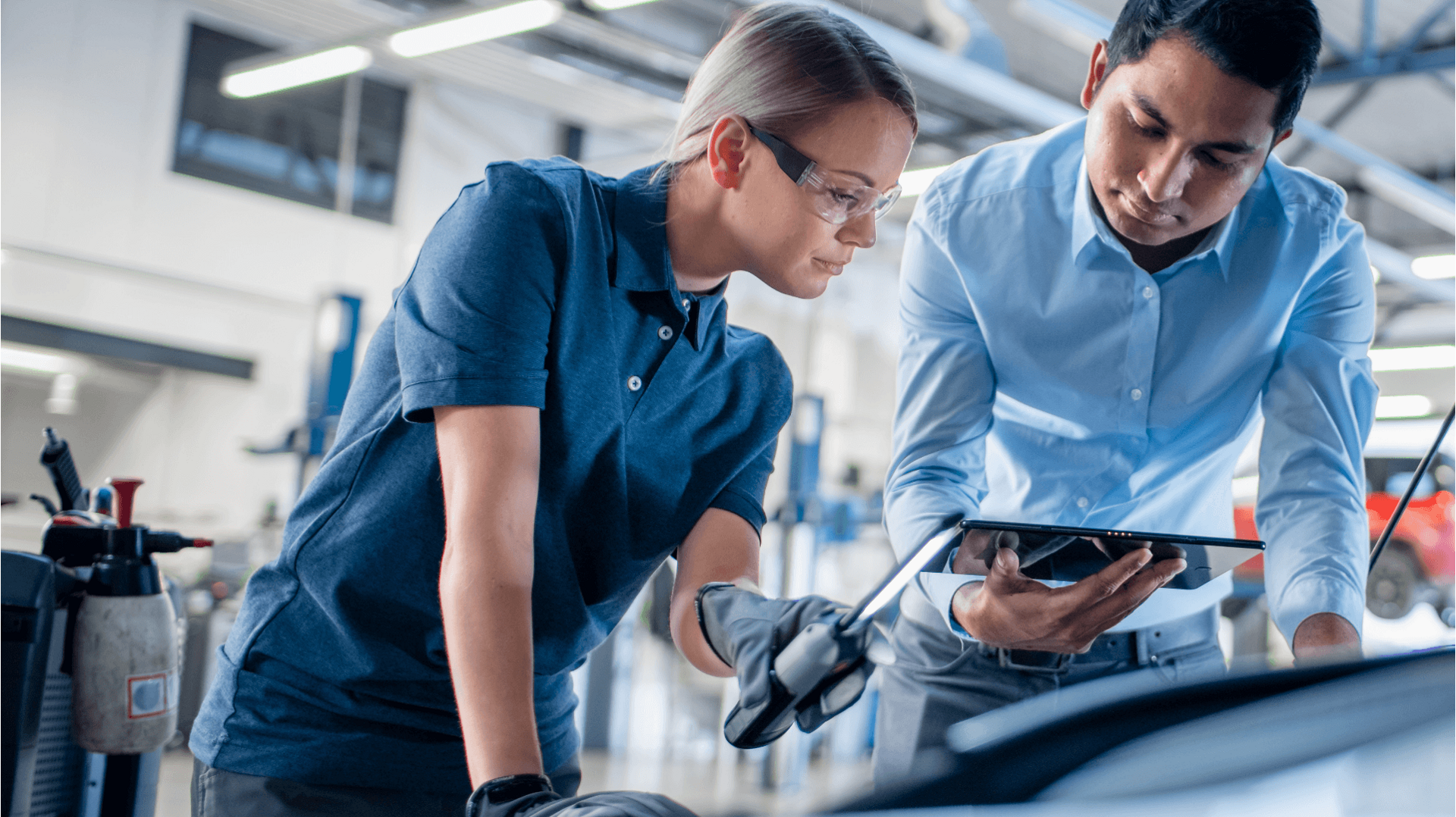 Delphi Technologies Experts using a tablet and an inspection lamp to investigate under the bonnet of a car.