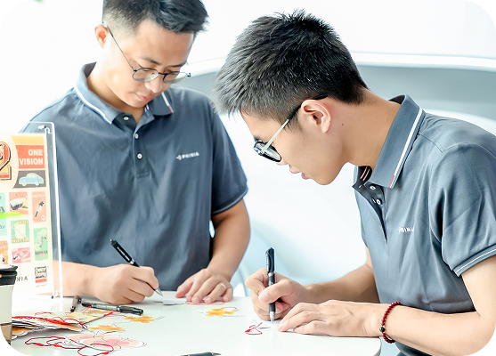 Two employees collaborating on a technical project at a workstation.