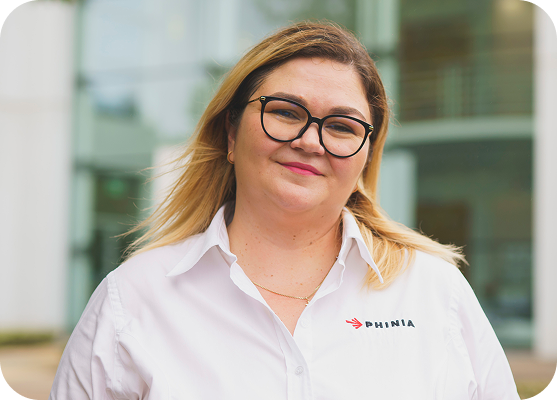 Portrait of a PHINIA employee smiling outside an office building.