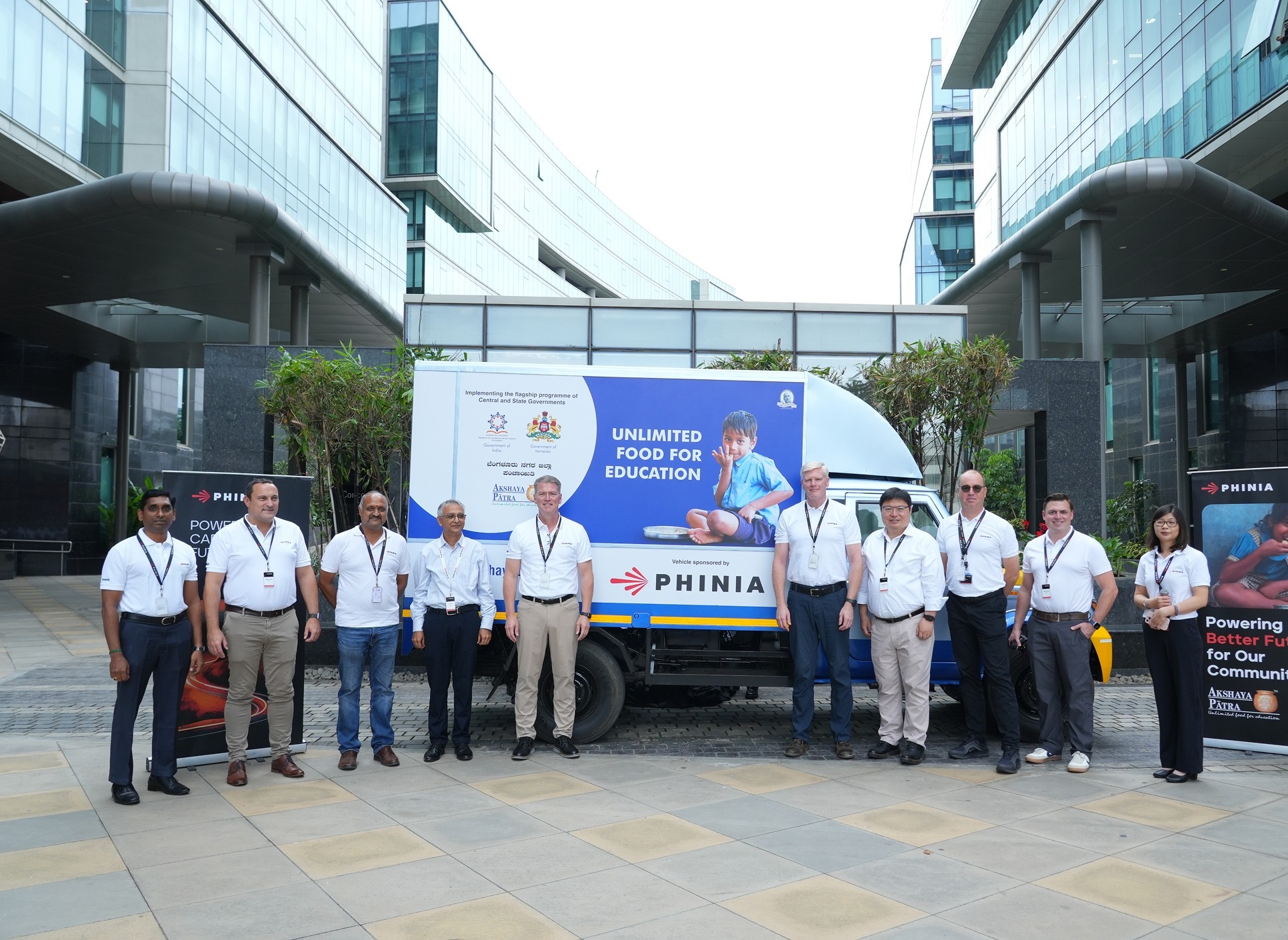 PHINIA employees participating in a community outreach event outside an office building.